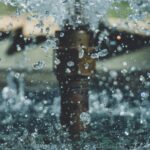 Close-up of water droplets mid-air from a fountain, capturing motion and clarity in an outdoor setting.